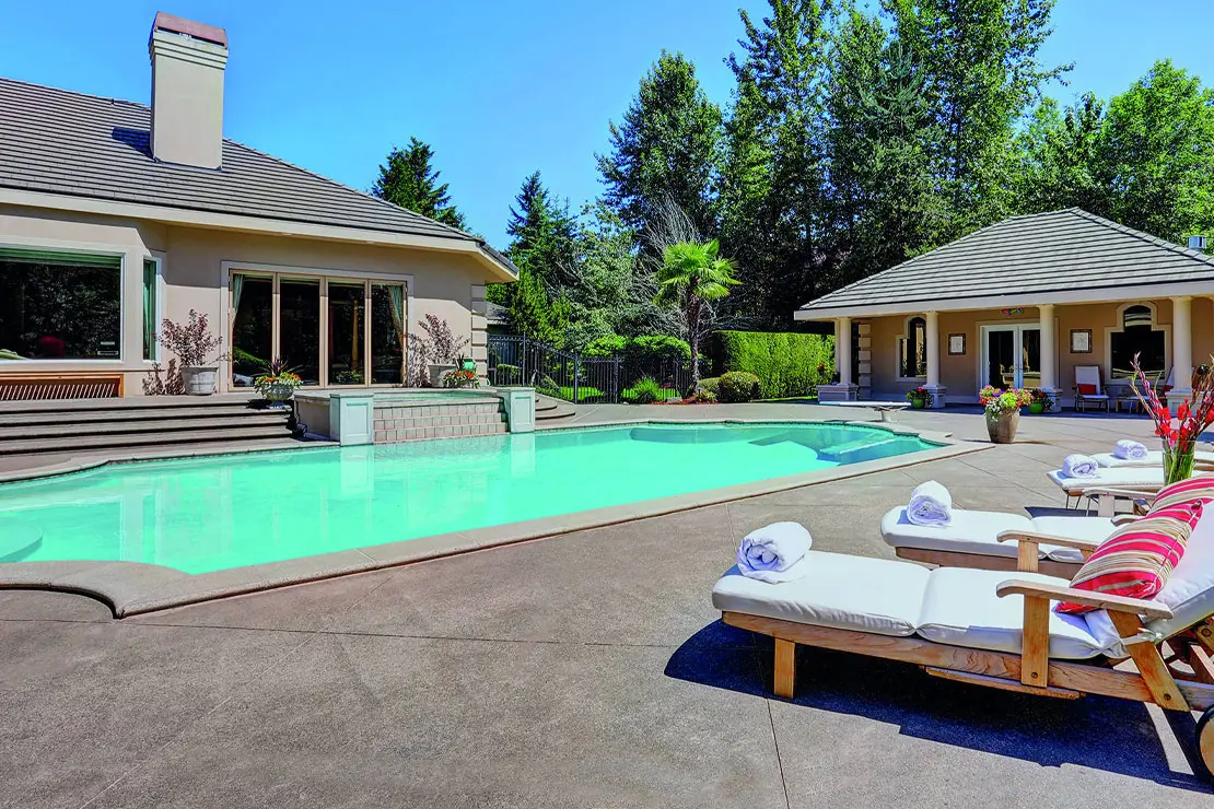 Casa con impresionante piscina revestida con hormigón impreso.